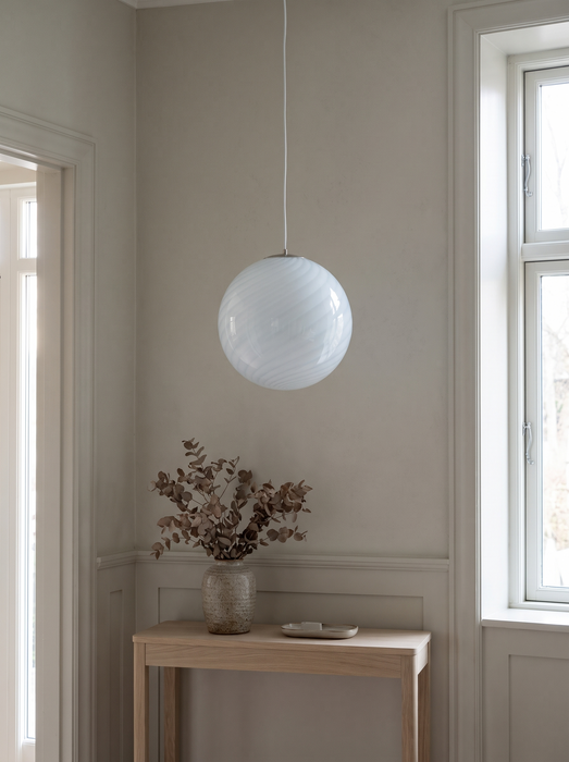 Hanging globe light above an entry console in a panelled hall – the white BO-HA Kaja swirl globe.