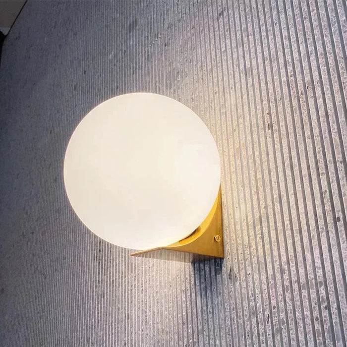 Solja – modern glass orb LED bedside wall sconce – gold finish with frosted glass globe