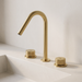 Kilde widespread bathroom faucet in brushed gold – knurled dual handles on a white stone basin