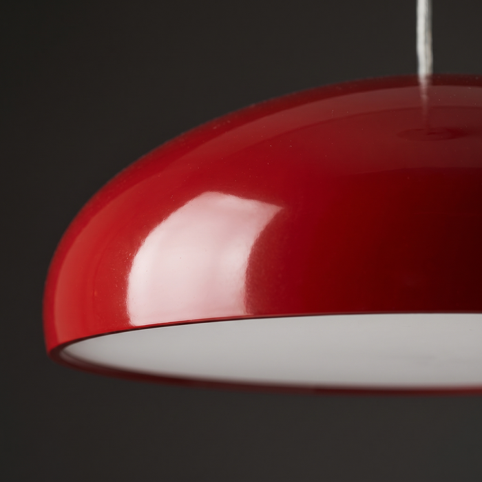 Red pendant light close-up — high-gloss dome shade with a white reflective interior